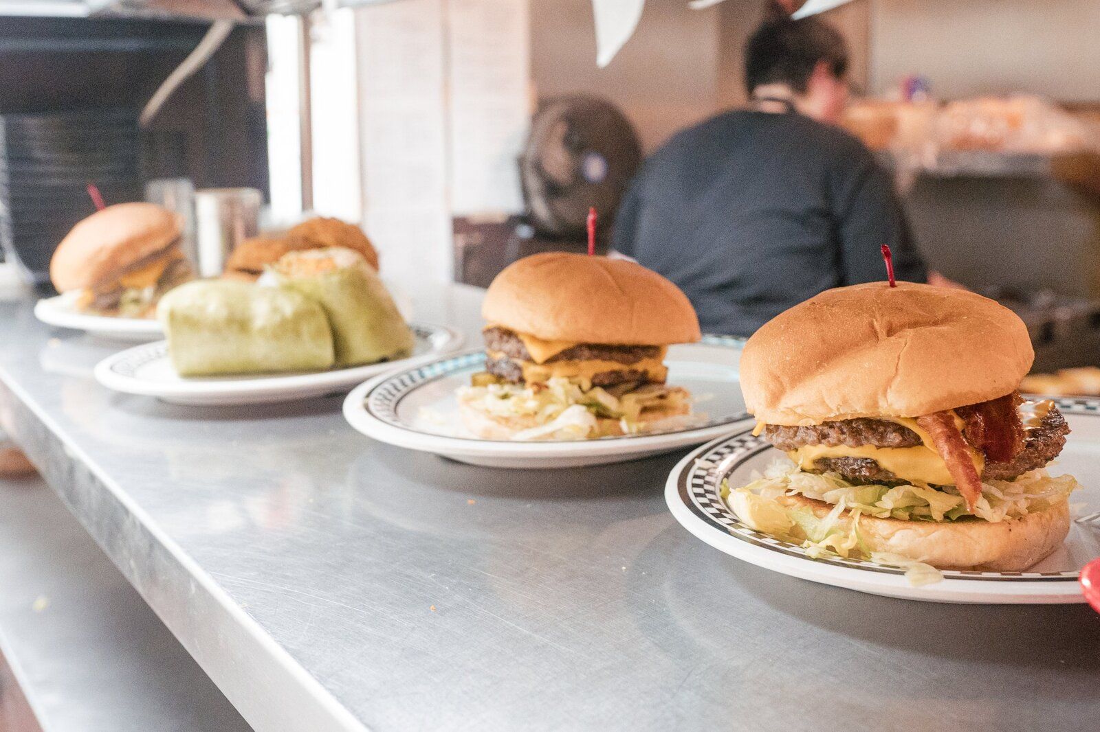 Hula hoop onion rings stacked beside a burger